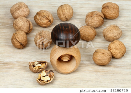 Wooden nutcracker in a mushroom shape and walnuts Wooden nutcracker in a mushroom shape and walnuts 38190729