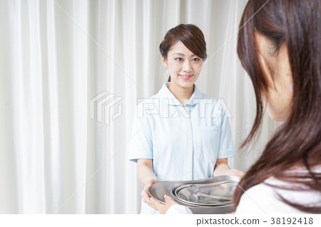 A nurse giving tools to a doctor 38192418