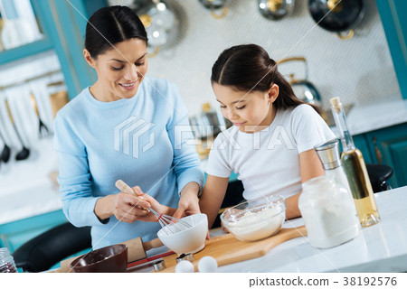 Loving mother and daughter making some cookies Loving mother and daughter making some cookies 38192576