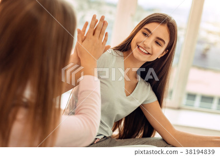 Pretty teenage sisters high-fiving each other Pretty teenage sisters high-fiving each other 38194839