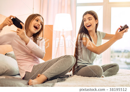 Upbeat teenage sisters playing video games 38195512