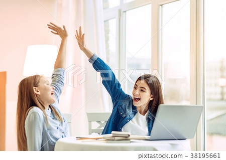 Upbeat girls giving each other high-five Upbeat girls giving each other high-five 38195661
