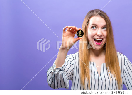 Woman holding a physical ethereum coin 38195923