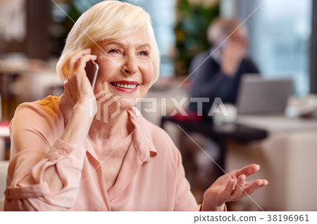 Cheerful mature woman receiving call Cheerful mature woman receiving call 38196961