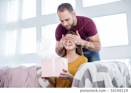 Happy young man making a gift to his beloved woman Happy young man making a gift to his beloved woman 38198129