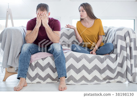Unhappy woman talking to her man about his 38198130