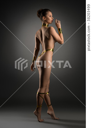 Nude girl with gold tape body adornment rearview 38203499