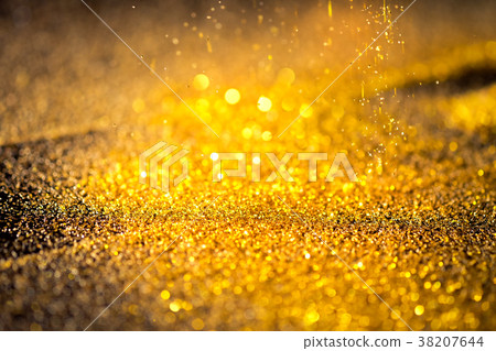Sprinkle gold shiny dust on a black background Sprinkle gold shiny dust on a black background 38207644