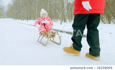 Happy little boy on the sledge in the winter park Happy little boy on the sledge in the winter park 38208009