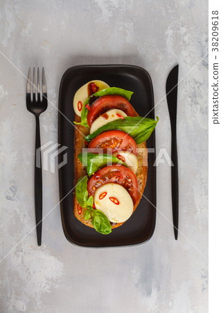 Caprese sandwich with mozzarella, tomato and basil 38209618