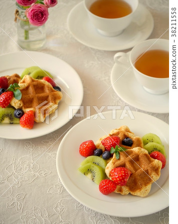 Kiwi and berry decoration waffles and tea 38211558