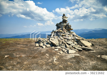Stone cairn on mountain against blue sky Stone cairn on mountain against blue sky 38211682