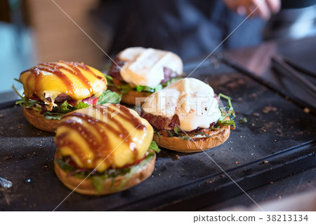 preparing burger adding the sauce on the cream 38213134