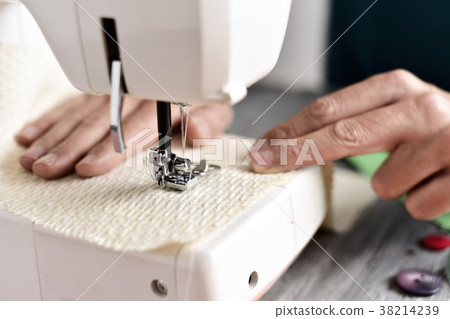young man using a sewing machine young man using a sewing machine 38214239
