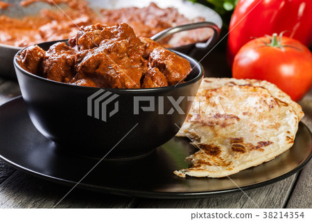 Chicken tikka masala served with bread naan 38214354