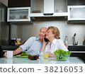 Senior woman talking on phone while man working in 38216053