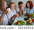 mature woman with family dinner at table, home 38216054