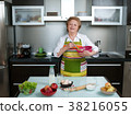 Beautiful and happy senior woman cooking at her 38216055