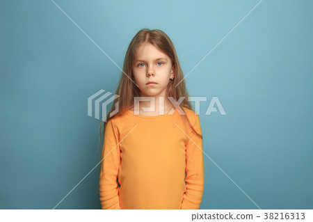 The serious teen girl on a blue background. Facial The serious teen girl on a blue background. Facial 38216313