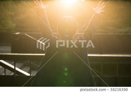 Woman holding hand to sun 38216390