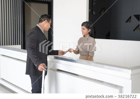 Man in Hotel check in at reception being given key 38216722