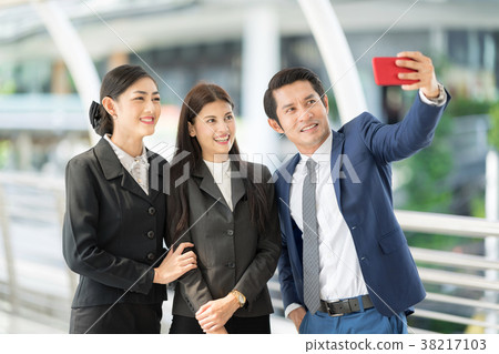 Businessman using smartphone selfie with partner. 38217103