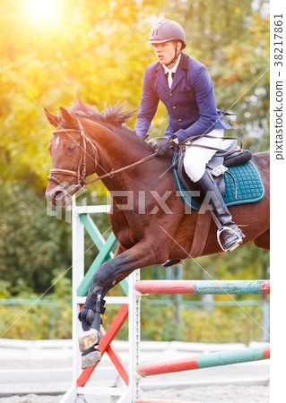 Young rider man jumping on equestrian competition 38217861