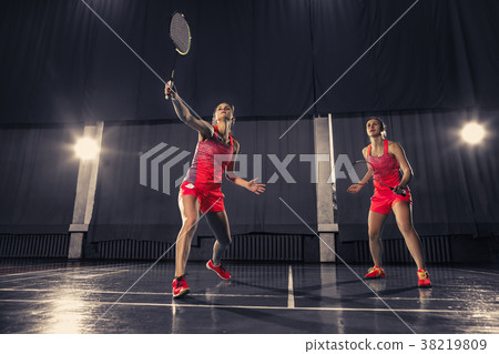 Young women playing badminton at gym Young women playing badminton at gym 38219809