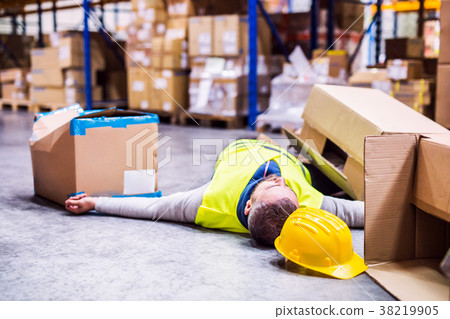 Warehouse worker after an accident in a warehouse. Warehouse worker after an accident in a warehouse. 38219905