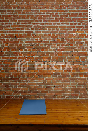 Gym mat on wooden podium, brick wall on background Gym mat on wooden podium, brick wall on background 38221808