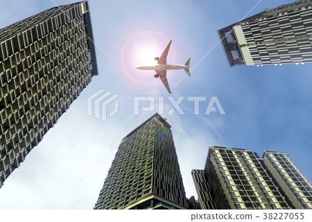 Airplane flying above office buildings 38227055