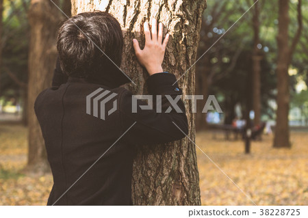 Men leaning on a tree 38228725