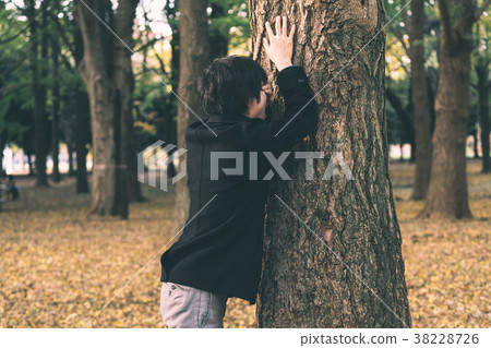 Men leaning on a tree 38228726