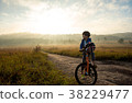 Boy rides a bicycle in the sunrise 38229477