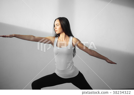 young woman wearing white tank top working out young woman wearing white tank top working out 38234322