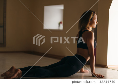 woman practicing yoga indoor. girl practice cobra woman practicing yoga indoor. girl practice cobra 38234710