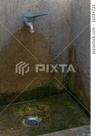 Old faucet with water stains and old cement wall. Old faucet with water stains and old cement wall. 38234712