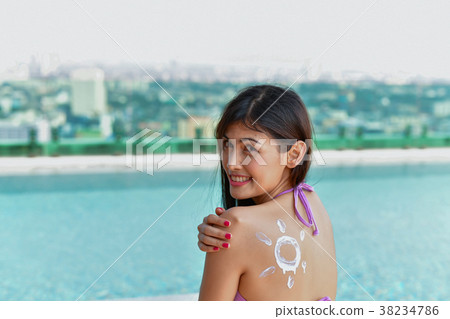 Swimsuit Concept. Beautiful girl in swimsuit is applying sunscre 38234786