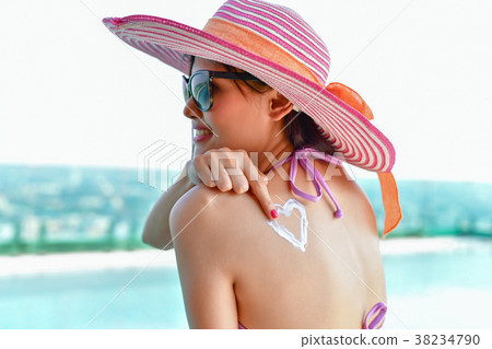 Swimsuit Concept. Beautiful girl in swimsuit is applying sunscre Swimsuit Concept. Beautiful girl in swimsuit is applying sunscre 38234790