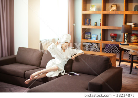 young woman in bathrobe drinking coffee and 38234875