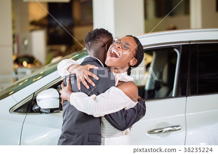 Couple collecting new car from salesman on lot 38235224