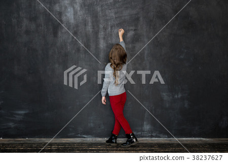 girl writing something with a chalk on blackboard girl writing something with a chalk on blackboard 38237627