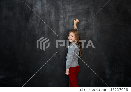 girl writing something with a chalk on blackboard girl writing something with a chalk on blackboard 38237628