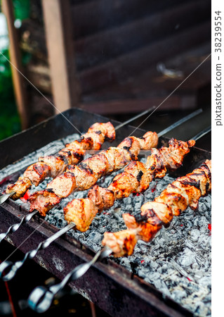 Grilled kebab cooking on metal skewer. Roasted Grilled kebab cooking on metal skewer. Roasted 38239554