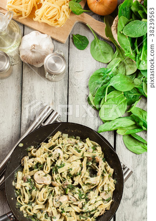 Tagliatelle pasta with spinach and mushrooms 38239563