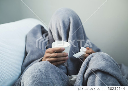 ill man warming up with a cup of hot milk 38239644