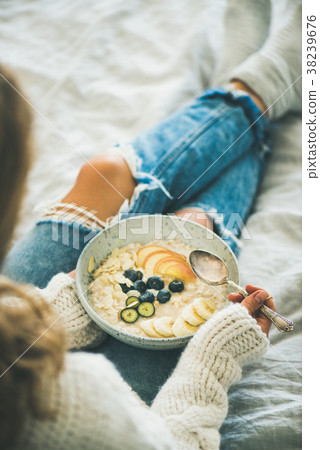 Woman in shabby jeans and sweater eating vegan 38239676
