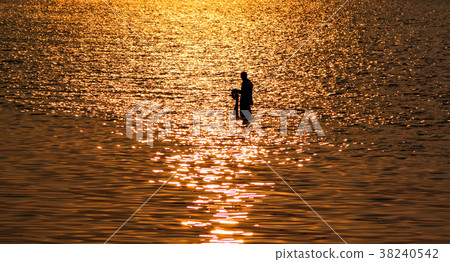 Fisherman with net in sea with sunset reflection Fisherman with net in sea with sunset reflection 38240542