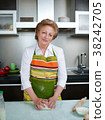 Happy elderly woman in the kitchen holding cooked 38242705