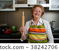 Happy elderly woman in the kitchen holding cooked 38242706